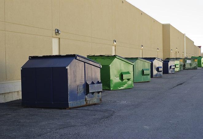 a row of yellow and blue dumpsters at a construction site in Ararat NC